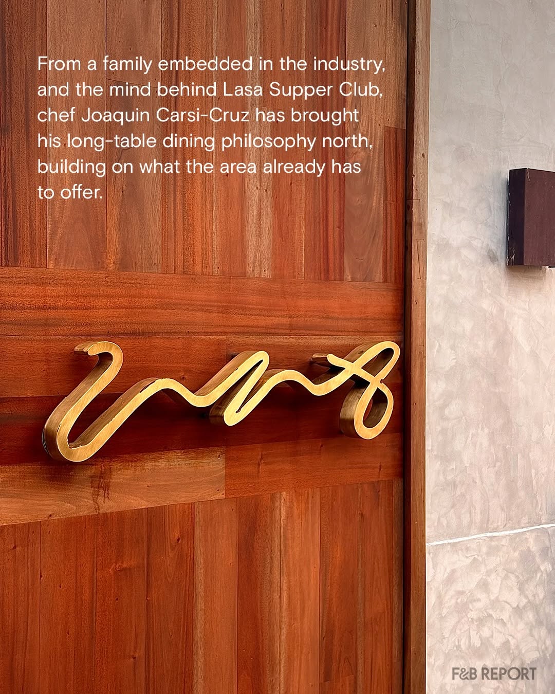 Gold UNA script logo on warm wood-paneled wall