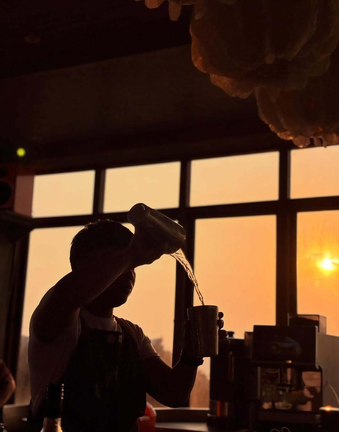 Bartender pouring cocktail at sunset